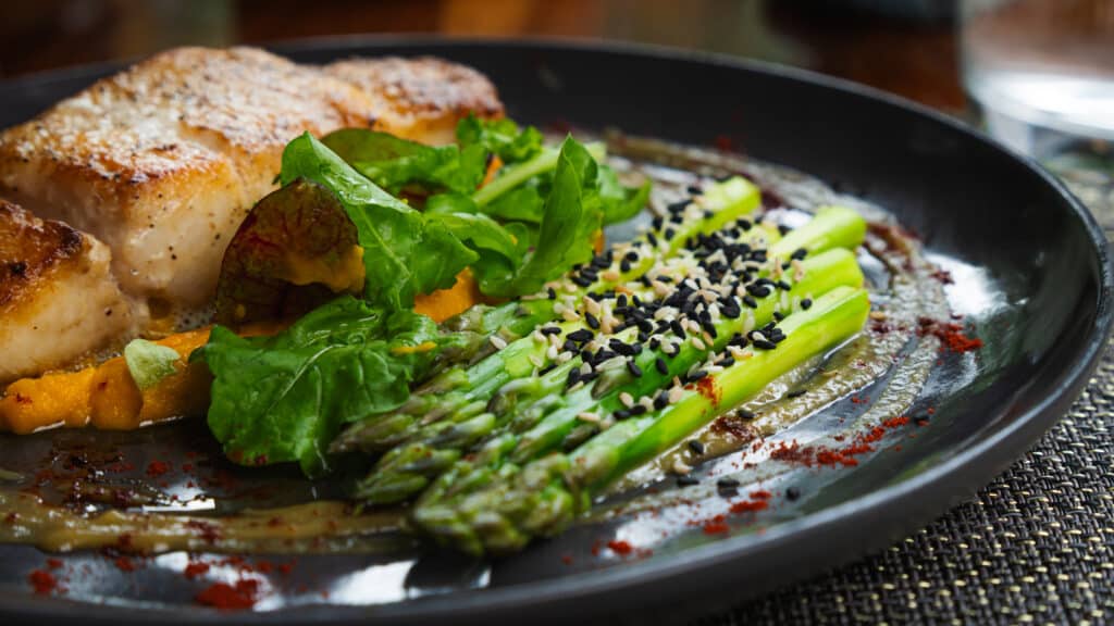 Grilled salmon with asparagus and mixed greens on plate