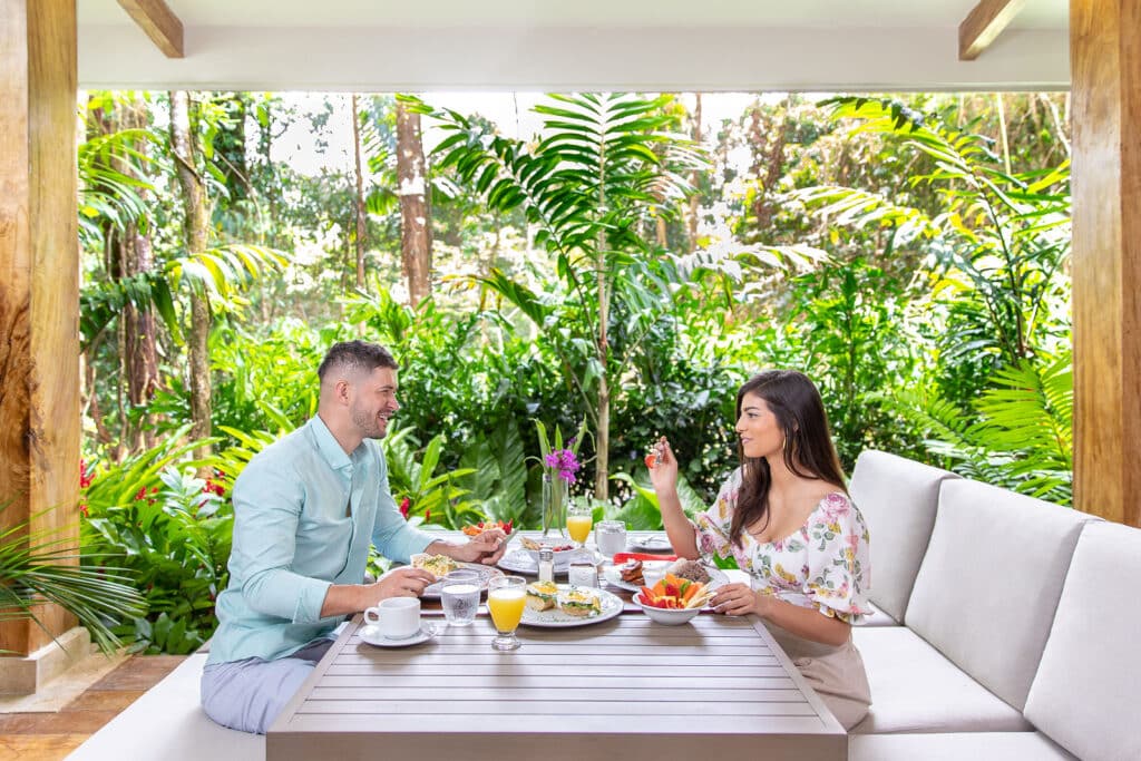 Couple enjoying breakfast in lush garden setting outdoors